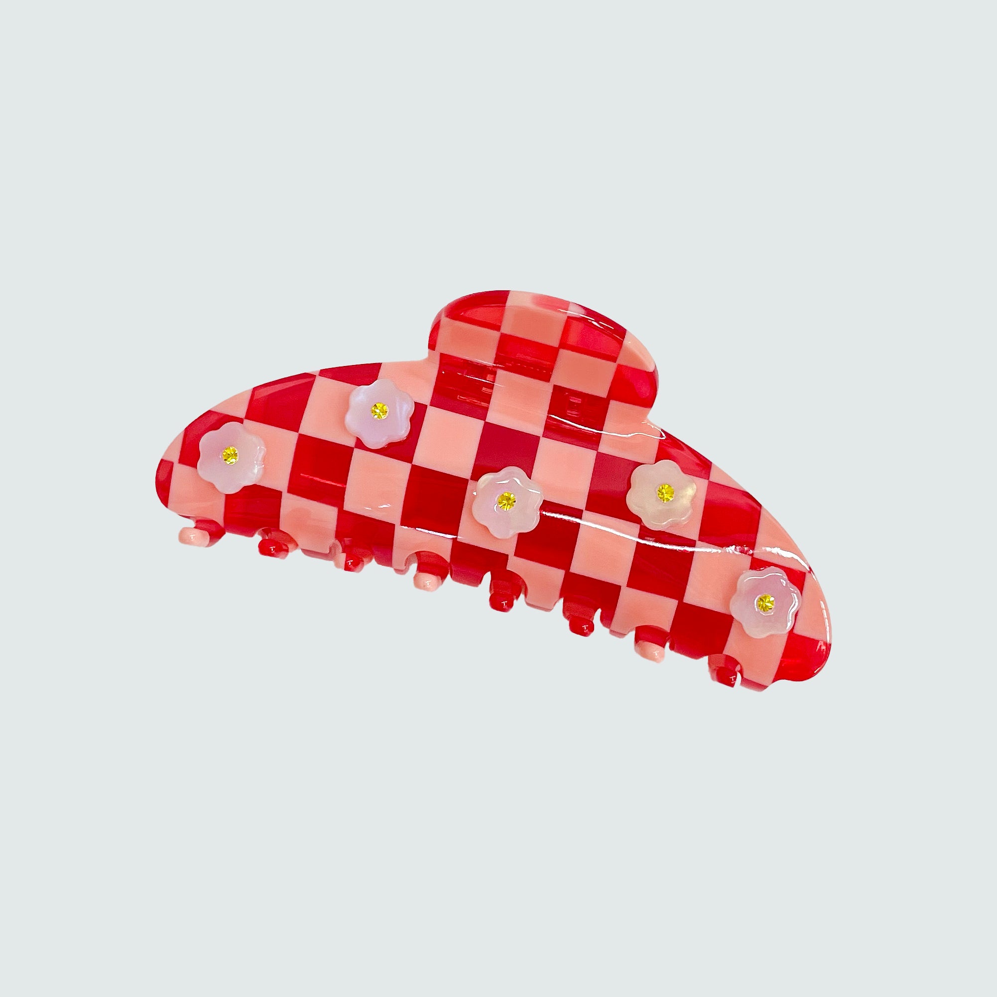 Red and white checkered hair clip with floral designs on a light gray background